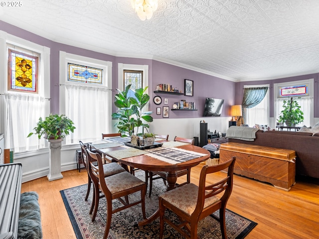 dining area featuring ornamental molding, plenty of natural light, and light hardwood / wood-style floors