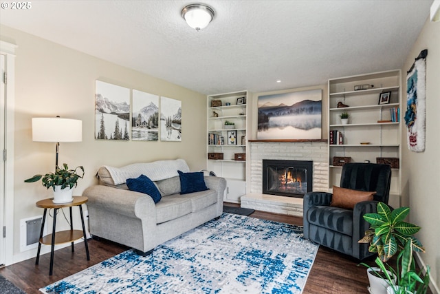 living room featuring wood finished floors, a textured ceiling, a fireplace, and recessed lighting