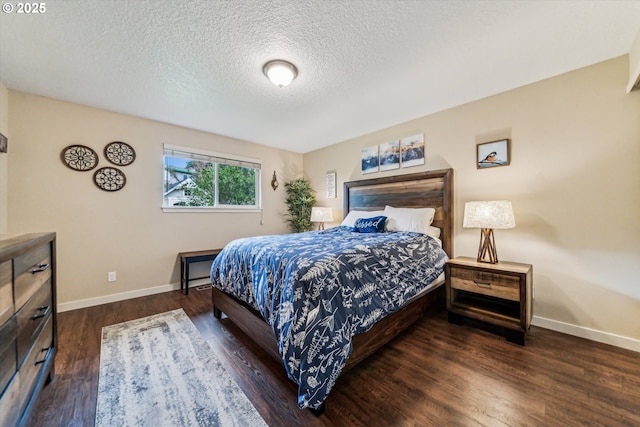bedroom with baseboards, dark wood-style flooring, and a textured ceiling