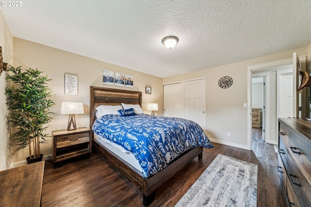 bedroom featuring dark wood-style flooring, baseboards, a closet, and a textured ceiling