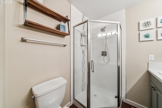 bathroom with a shower stall, vanity, and toilet