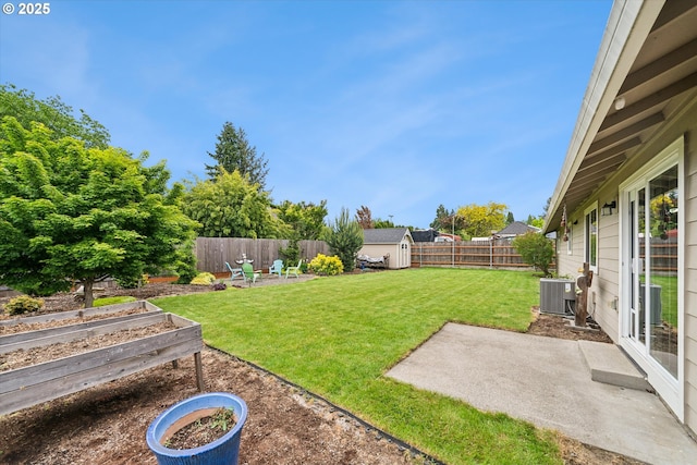 view of yard with a vegetable garden, a patio, a storage shed, and central AC