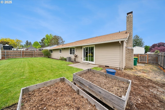 rear view of property featuring a vegetable garden, a chimney, and central AC unit