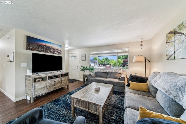 living area with dark wood-style floors, baseboards, and a textured ceiling