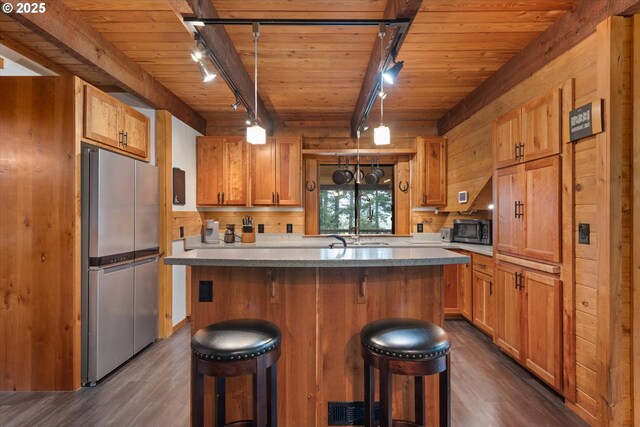 67388 Timberline Rd, Summerville, OR 97876 - kitchen featuring track lighting, freestanding refrigerator, dark wood-style flooring, wooden ceiling, and a breakfast bar