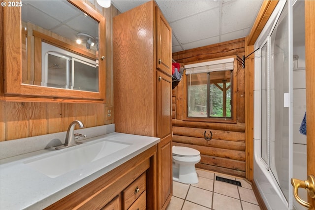 67388 Timberline Rd, Summerville, OR 97876 - bathroom with a paneled ceiling, rustic walls, toilet, vanity, and tile patterned floors