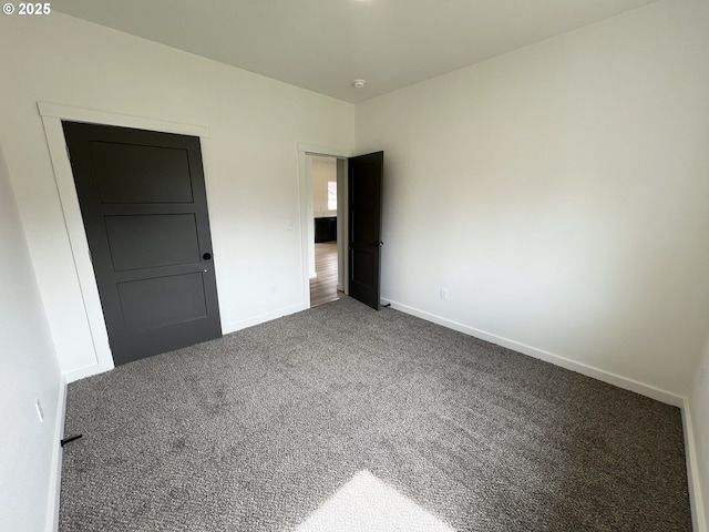 unfurnished bedroom with baseboards and carpet flooring
