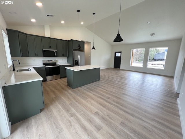 kitchen with a sink, high vaulted ceiling, stainless steel appliances, a kitchen island, and visible vents