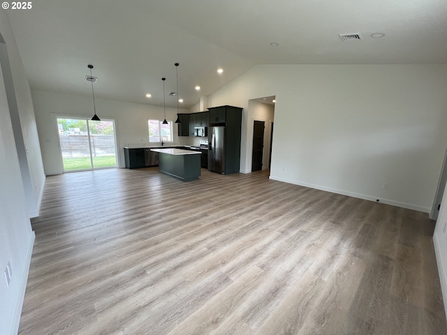 kitchen with visible vents, a center island, lofted ceiling, stainless steel appliances, and open floor plan