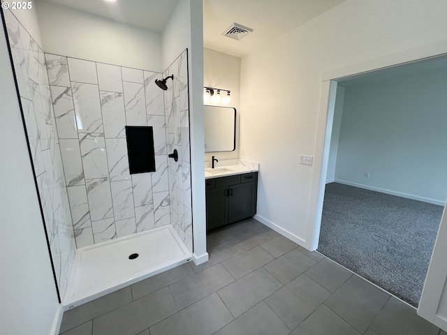 full bath featuring visible vents, tile patterned flooring, vanity, baseboards, and tiled shower