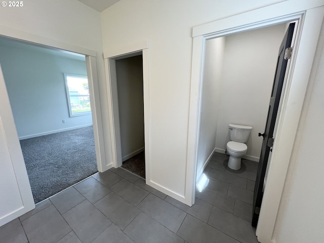 bathroom with tile patterned floors, baseboards, and toilet
