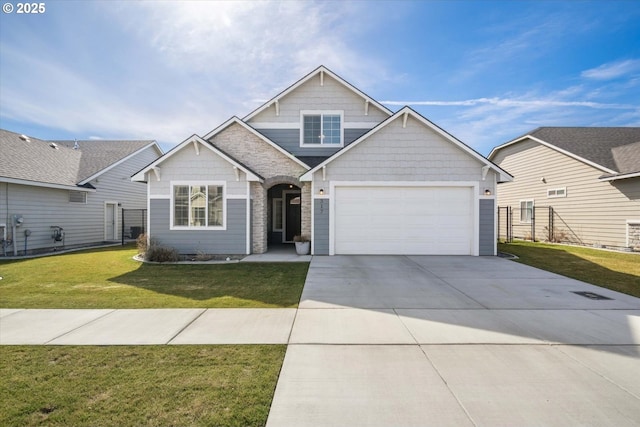 view of front facade featuring fence, a front lawn, concrete driveway, a garage, and stone siding