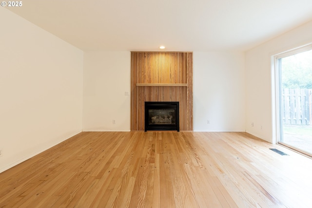 3166 NE Glencoe Oaks Pl, Hillsboro, OR 97124 - unfurnished living room with light wood-style flooring, a large fireplace, and recessed lighting