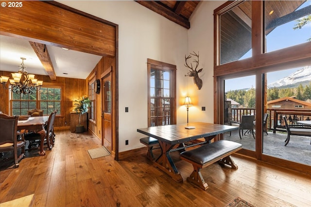 dining space featuring a chandelier, hardwood / wood-style floors, healthy amount of natural light, and baseboards