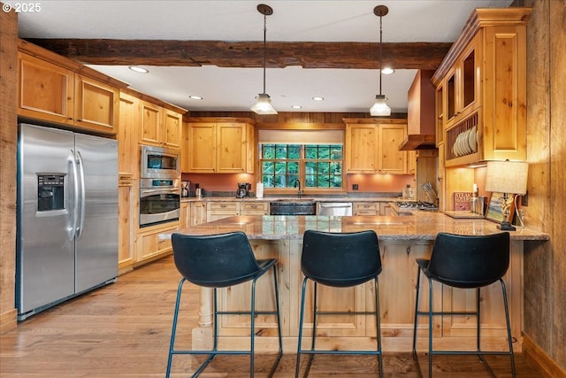 kitchen featuring stainless steel appliances, beamed ceiling, a peninsula, light wood-type flooring, and light stone counters