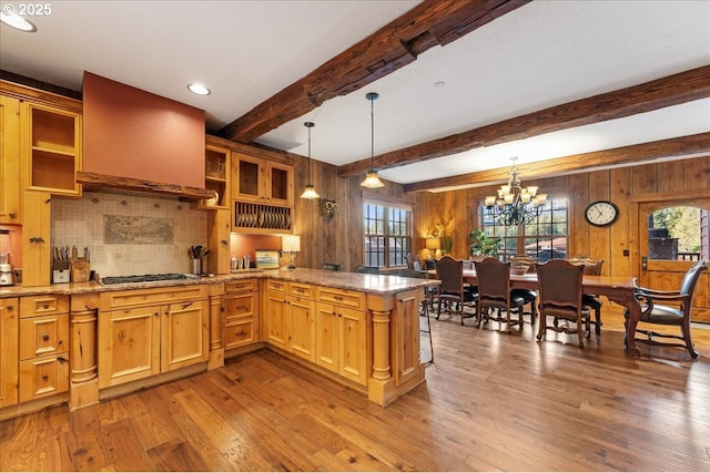 kitchen with healthy amount of natural light, a peninsula, custom exhaust hood, open shelves, and beam ceiling