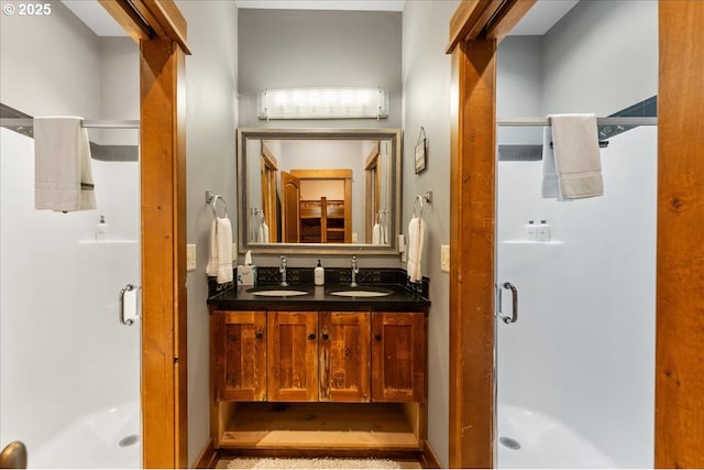 full bath featuring a shower stall and double vanity