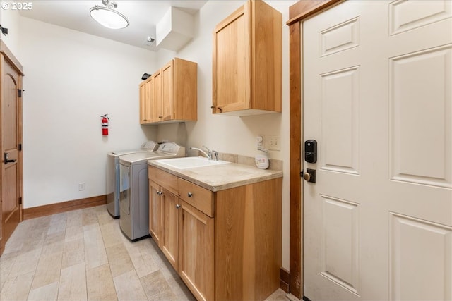 clothes washing area featuring cabinet space, separate washer and dryer, and baseboards