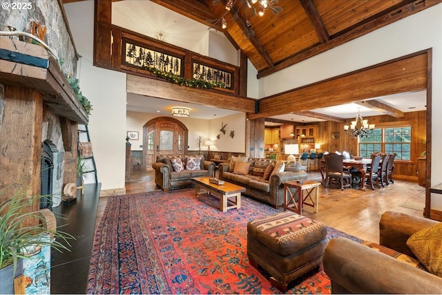 living area with beamed ceiling, wood finished floors, wooden ceiling, a chandelier, and high vaulted ceiling