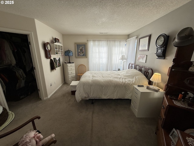 carpeted bedroom featuring visible vents, a textured ceiling, and baseboards