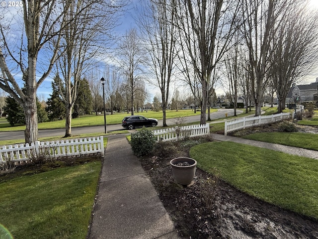 view of home's community featuring fence and a lawn