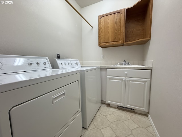 1000 NE Park Edge Cir, Hillsboro, OR 97124 - clothes washing area featuring washer and clothes dryer, cabinet space, light tile patterned flooring, and baseboards