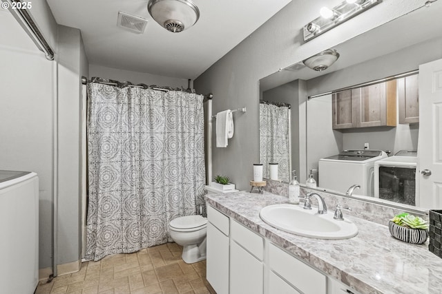 full bathroom featuring separate washer and dryer, vanity, curtained shower, toilet, and visible vents