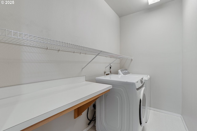 laundry room with washing machine and clothes dryer, laundry area, and baseboards