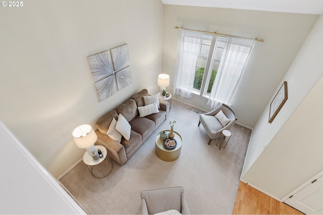 living area with wood finished floors, visible vents, and baseboards