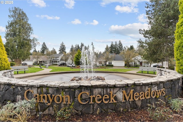 community sign with a lawn and a residential view