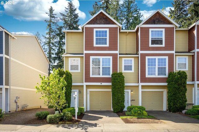 townhome / multi-family property featuring aphalt driveway and an attached garage