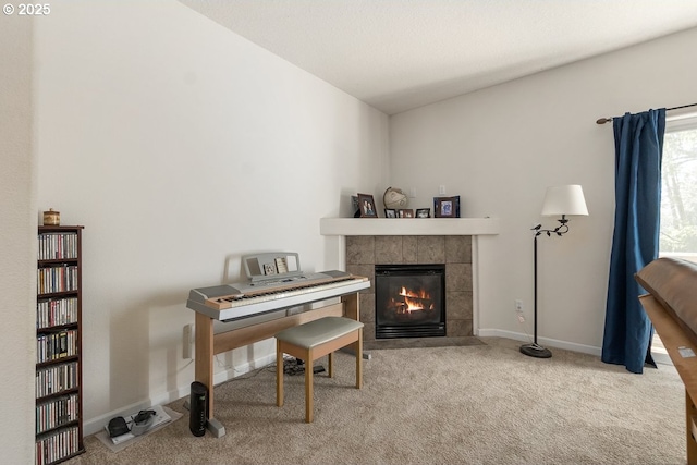 living area with a tile fireplace, carpet floors, and baseboards