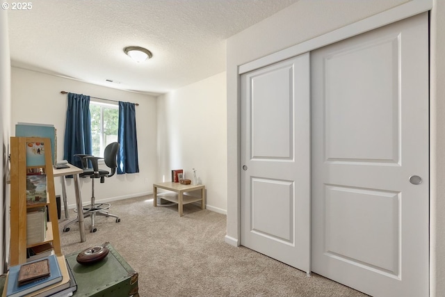 carpeted home office with baseboards, visible vents, and a textured ceiling