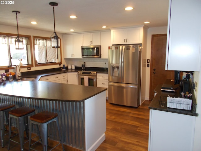 43497 Shetland Ct, Pendleton, OR 97801 - kitchen featuring appliances with stainless steel finishes, a sink, dark countertops, a peninsula, and recessed lighting