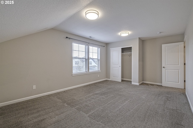 unfurnished bedroom with vaulted ceiling, carpet floors, a closet, and baseboards