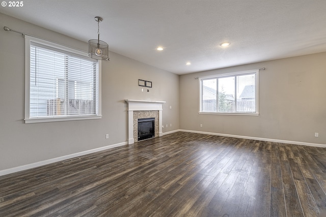 unfurnished living room with dark wood-style flooring, a fireplace, recessed lighting, visible vents, and baseboards