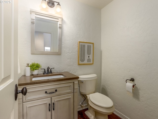 14066 Edenberry Dr, Lake Oswego, OR 97035 - half bathroom featuring vanity, toilet, a textured wall, wood finished floors, and baseboards