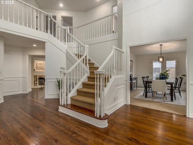 14066 Edenberry Dr, Lake Oswego, OR 97035 - staircase featuring a towering ceiling, wood finished floors, and a decorative wall