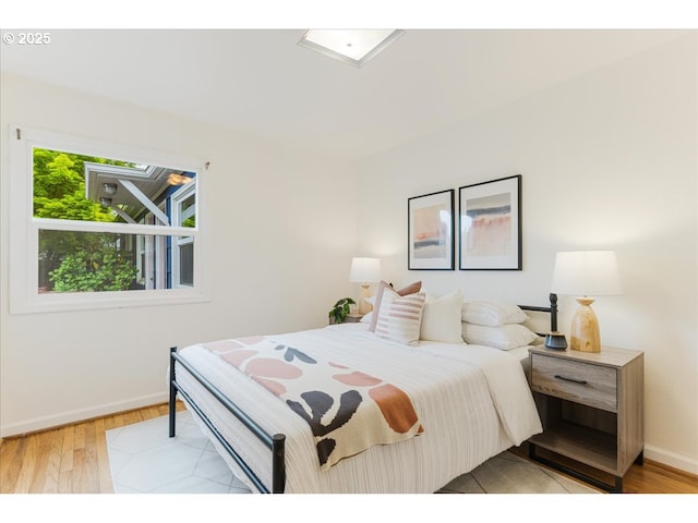 bedroom with light wood-style floors and baseboards