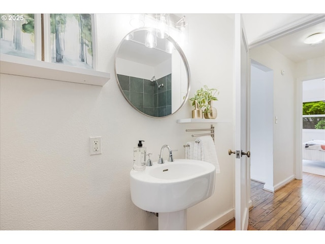bathroom with baseboards, a sink, and hardwood / wood-style floors