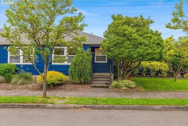 5310 NE 10th Ave, Portland, OR 97211 - view of property hidden behind natural elements with a front yard and roof with shingles