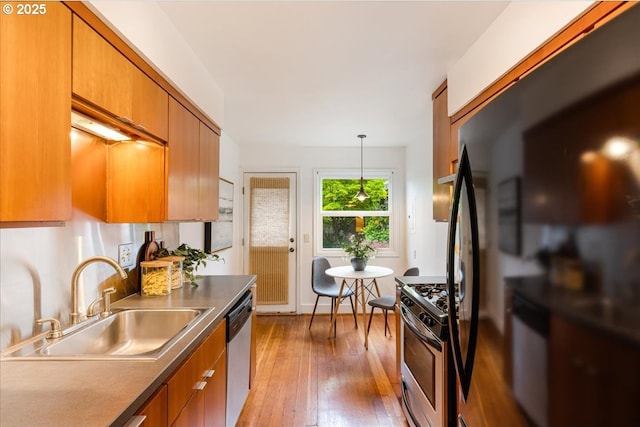 5310 NE 10th Ave, Portland, OR 97211 - kitchen featuring brown cabinets, stainless steel appliances, a sink, and light wood-style floors