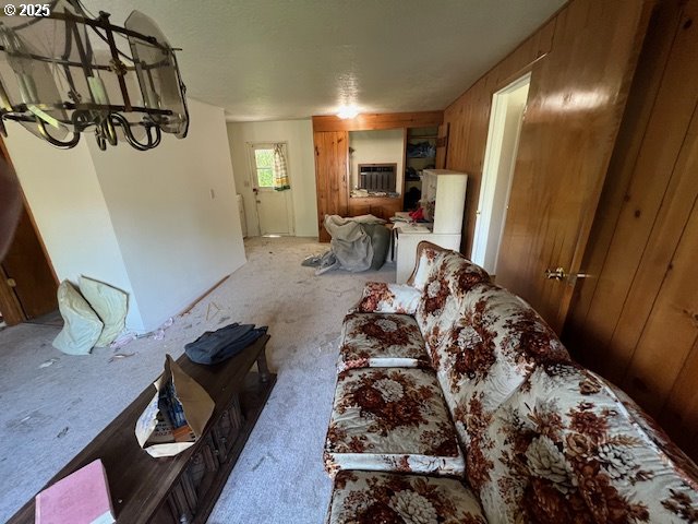 living room with a wall unit AC and wood walls