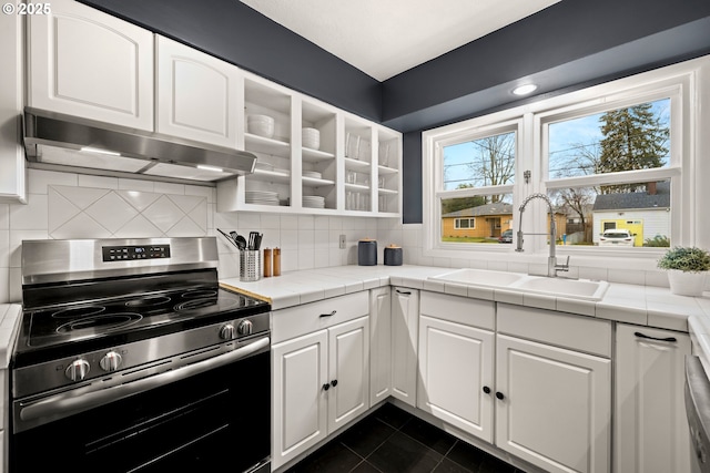 kitchen featuring a sink, decorative backsplash, stainless steel range with electric cooktop, white cabinets, and under cabinet range hood