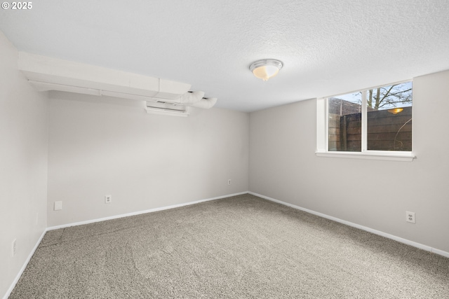 empty room with carpet flooring, a textured ceiling, and baseboards