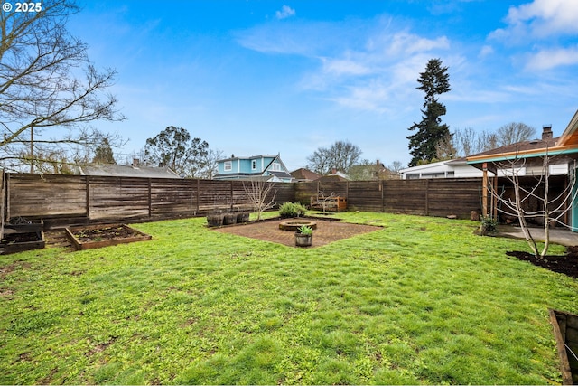 view of yard with a garden and a fenced backyard