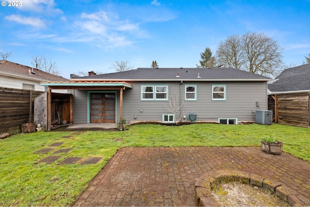 rear view of house with central AC, a fenced backyard, a yard, french doors, and a patio area