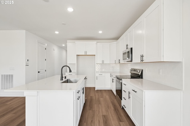 11016 NE 131st Ct, Vancouver, WA 98682 - kitchen with appliances with stainless steel finishes, a sink, wood finished floors, decorative backsplash, and an island with sink