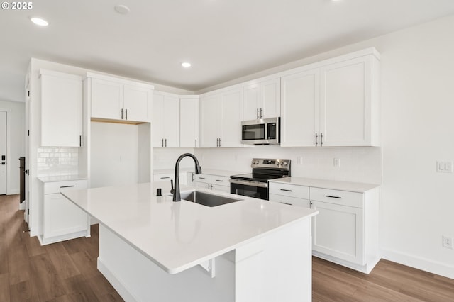 11016 NE 131st Ct, Vancouver, WA 98682 - kitchen featuring stainless steel appliances, a sink, wood finished floors, backsplash, and a center island with sink