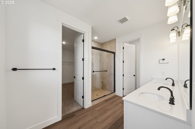 11016 NE 131st Ct, Vancouver, WA 98682 - bathroom featuring a shower stall, wood finished floors, double vanity, a walk in closet, and baseboards